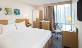 King bed with natural light and work desk at Hilton Garden Inn Bristol City Centre.