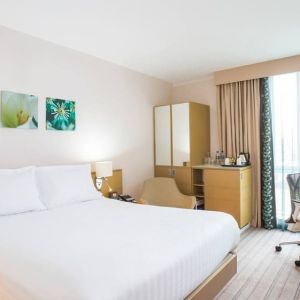 King bed with natural light and work station at Hilton Garden Inn Glasgow City Centre.