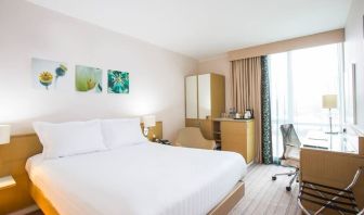 King bed with natural light and work station at Hilton Garden Inn Glasgow City Centre.