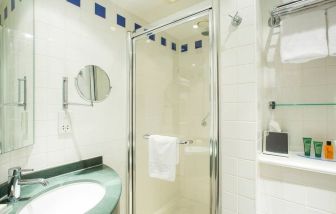 Private guest bathroom with shower at Hilton Garden Inn Glasgow City Centre.