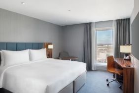 King bed with TV and work station at Hilton Garden Inn London Heathrow Terminals 2 And 3.