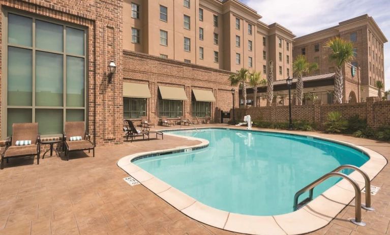 Outdoor pool with pool chairs at Embassy Suites By Hilton Savannah.