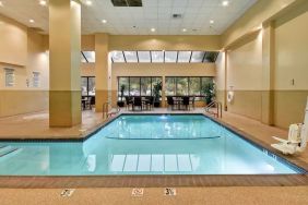 Relaxing indoor pool with seating area at Embassy Suites By Hilton Santa Clara Silicon Valley.