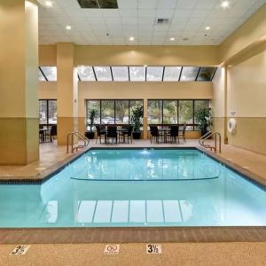 Relaxing indoor pool with seating area at Embassy Suites By Hilton Santa Clara Silicon Valley.