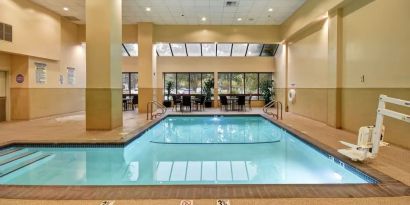 Relaxing indoor pool with seating area at Embassy Suites By Hilton Santa Clara Silicon Valley.