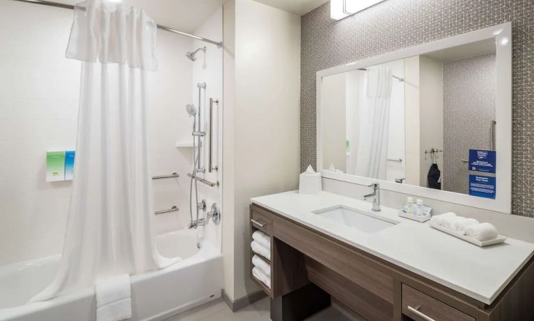 Private guest bathroom with shower and bath at Home2 Suites By Hilton Cape Canaveral Cruise Port.