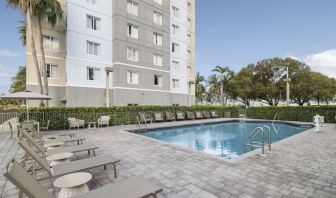 Loungers beside outdoor pool at Homewood Suites By Hilton Miami Airport-Blue Lagoon.