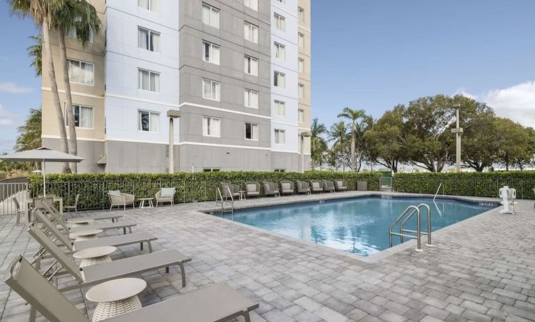 Relaxing pool area with pool chairs at Homewood Suites By Hilton Miami Airport-Blue Lagoon.