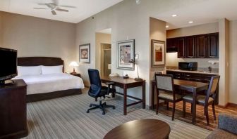 Spacious king bed with business desk at Homewood Suites By Hilton Burlington.