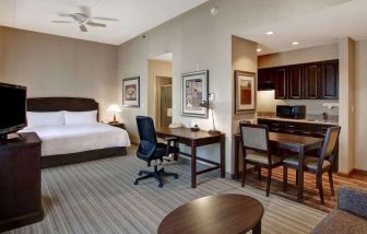 Spacious king bed with business desk at Homewood Suites By Hilton Burlington.