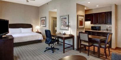 Spacious king bed with business desk at Homewood Suites By Hilton Burlington.