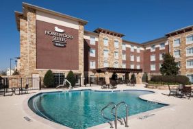 Lovely outdoor pool with seating area at Homewood Suites By Hilton Denton.