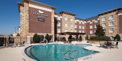 Lovely outdoor pool with seating area at Homewood Suites By Hilton Denton.