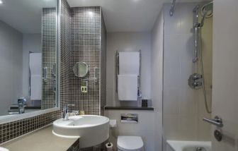 Guest bathroom with shower and bath at DoubleTree By Hilton Stratford-upon-Avon.