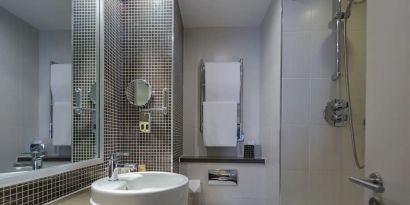 Guest bathroom with shower and bath at DoubleTree By Hilton Stratford-upon-Avon.