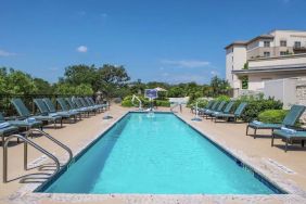 Stunning outdoor pool with pool chairs at Hilton San Antonio Hill Country.