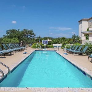 Stunning outdoor pool with pool chairs at Hilton San Antonio Hill Country.