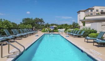 Stunning outdoor pool with pool chairs at Hilton San Antonio Hill Country.