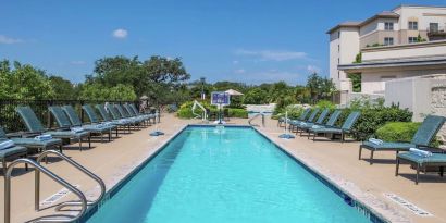 Stunning outdoor pool with pool chairs at Hilton San Antonio Hill Country.