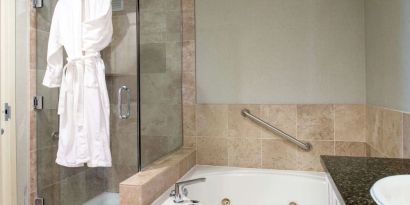 Guest bathroom with shower and bath at Hilton San Antonio Hill Country.