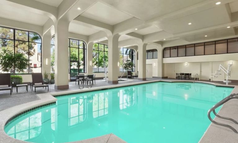 Lovely indoor pool with seating area at Embassy Suites By Hilton Arcadia Pasadena Area.