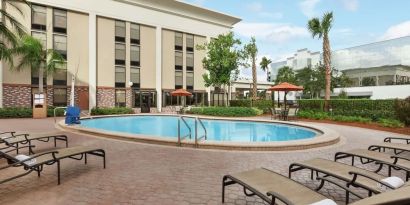 Stunning outdoor pool with pool chairs at Hampton Inn Ft. Lauderdale-Cypress Creek.