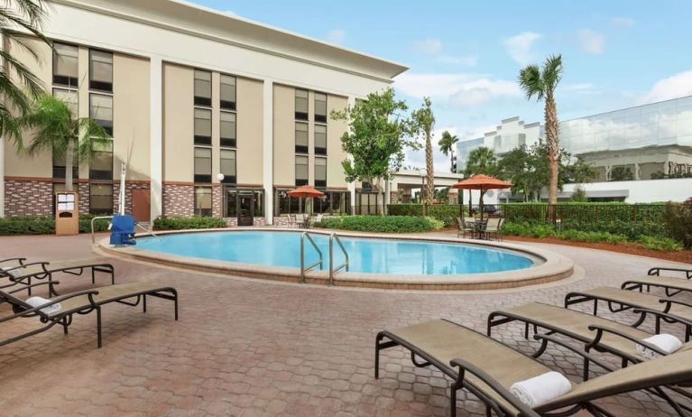 Stunning outdoor pool with pool chairs at Hampton Inn Ft. Lauderdale-Cypress Creek.