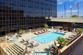 Stunning outdoor pool with pool chairs at Hilton Los Angeles Airport.