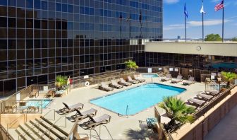 Stunning outdoor pool with pool chairs at Hilton Los Angeles Airport.