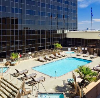 Stunning outdoor pool with pool chairs at Hilton Los Angeles Airport.