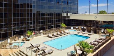 Stunning outdoor pool with pool chairs at Hilton Los Angeles Airport.