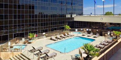 Stunning outdoor pool with pool chairs at Hilton Los Angeles Airport.