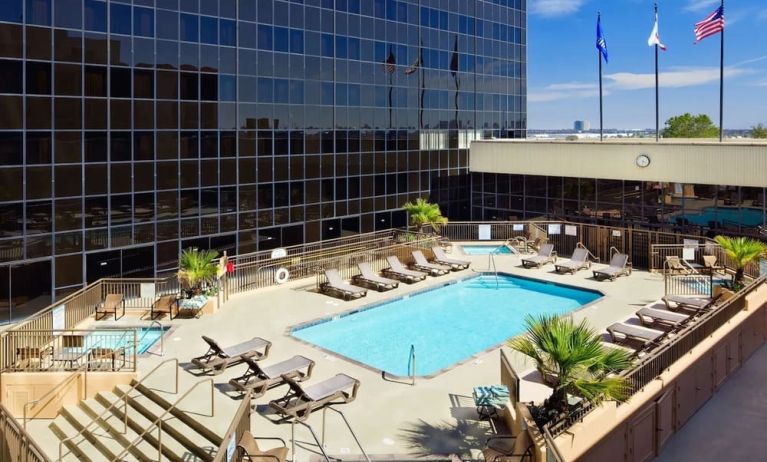 Stunning outdoor pool with pool chairs at Hilton Los Angeles Airport.