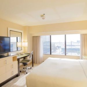 King bed with TV and business desk at Hilton Los Angeles Airport.