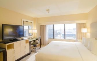 King bed with TV and business desk at Hilton Los Angeles Airport.