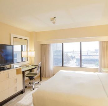 King bed with TV and business desk at Hilton Los Angeles Airport.