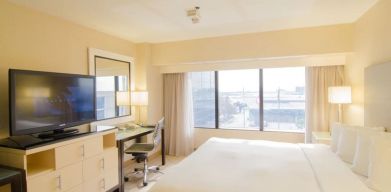 King bed with TV and business desk at Hilton Los Angeles Airport.