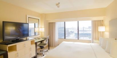 King bed with TV and business desk at Hilton Los Angeles Airport.