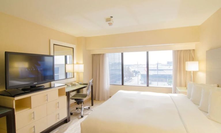 King bed with TV and business desk at Hilton Los Angeles Airport.