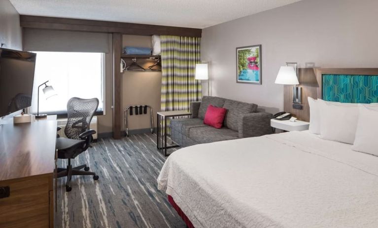 Delux king bed with desk and chair at Hampton Inn Bentonville/Rogers.