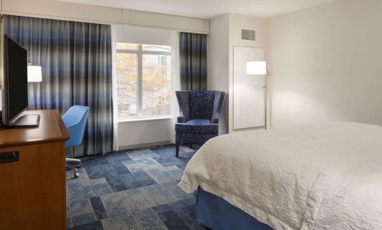 King bed with natural light at Hampton Inn & Suites Rosemont Chicago O'Hare.