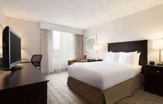 King bed room with TV and work desk at DoubleTree By Hilton Hartford - Bradley Airport.