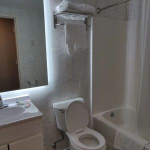 Guest bathroom with shower and bath at Hotel Key.