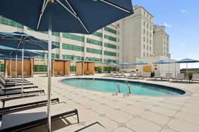 Stunning outdoor pool with pool chairs at Hilton Baton Rouge Capitol Center.