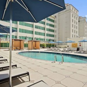 Stunning outdoor pool with pool chairs at Hilton Baton Rouge Capitol Center.