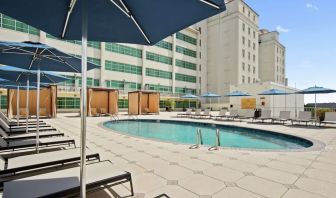 Stunning outdoor pool with pool chairs at Hilton Baton Rouge Capitol Center.