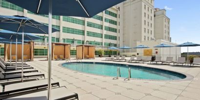 Stunning outdoor pool with pool chairs at Hilton Baton Rouge Capitol Center.