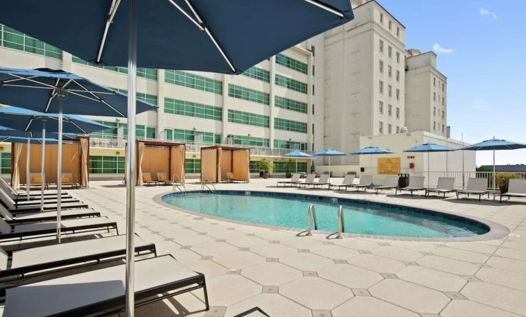 Stunning outdoor pool with pool chairs at Hilton Baton Rouge Capitol Center.