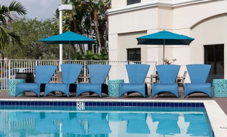 Outdoor pool with comfortable pool chairs at Hampton Inn & Suites Miami-Doral/Dolphin Mall.