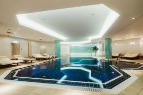 Stunning indoor pool with pool chairs at Hilton Berlin.